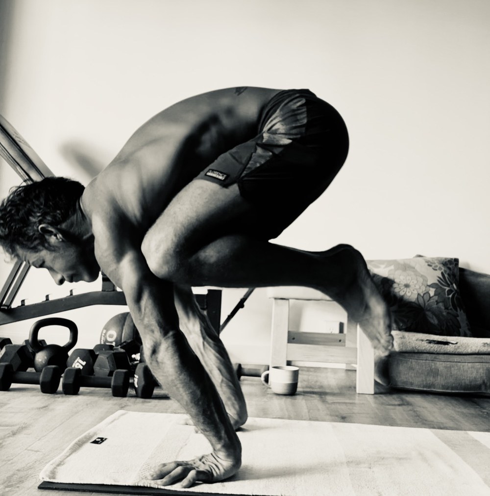 Armando in a lifted lotus yoga pose — a portrait of 26 years of Ashtanga practice